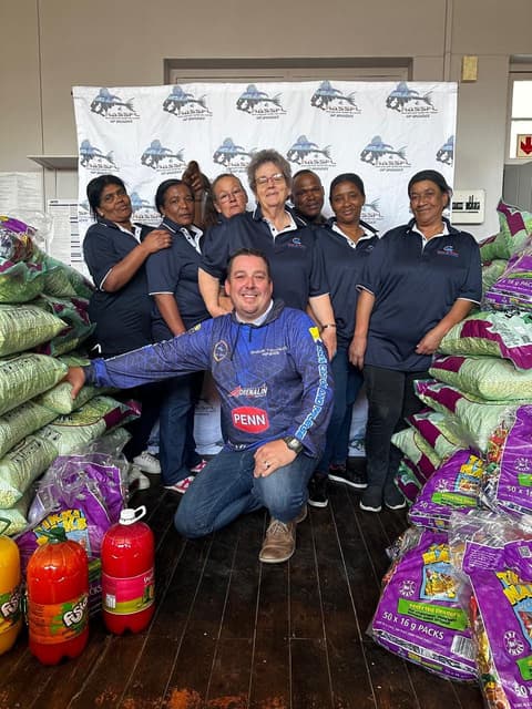 WP Bronzies members, supporters and volunteers gathered with donated food supplies at a community handover event