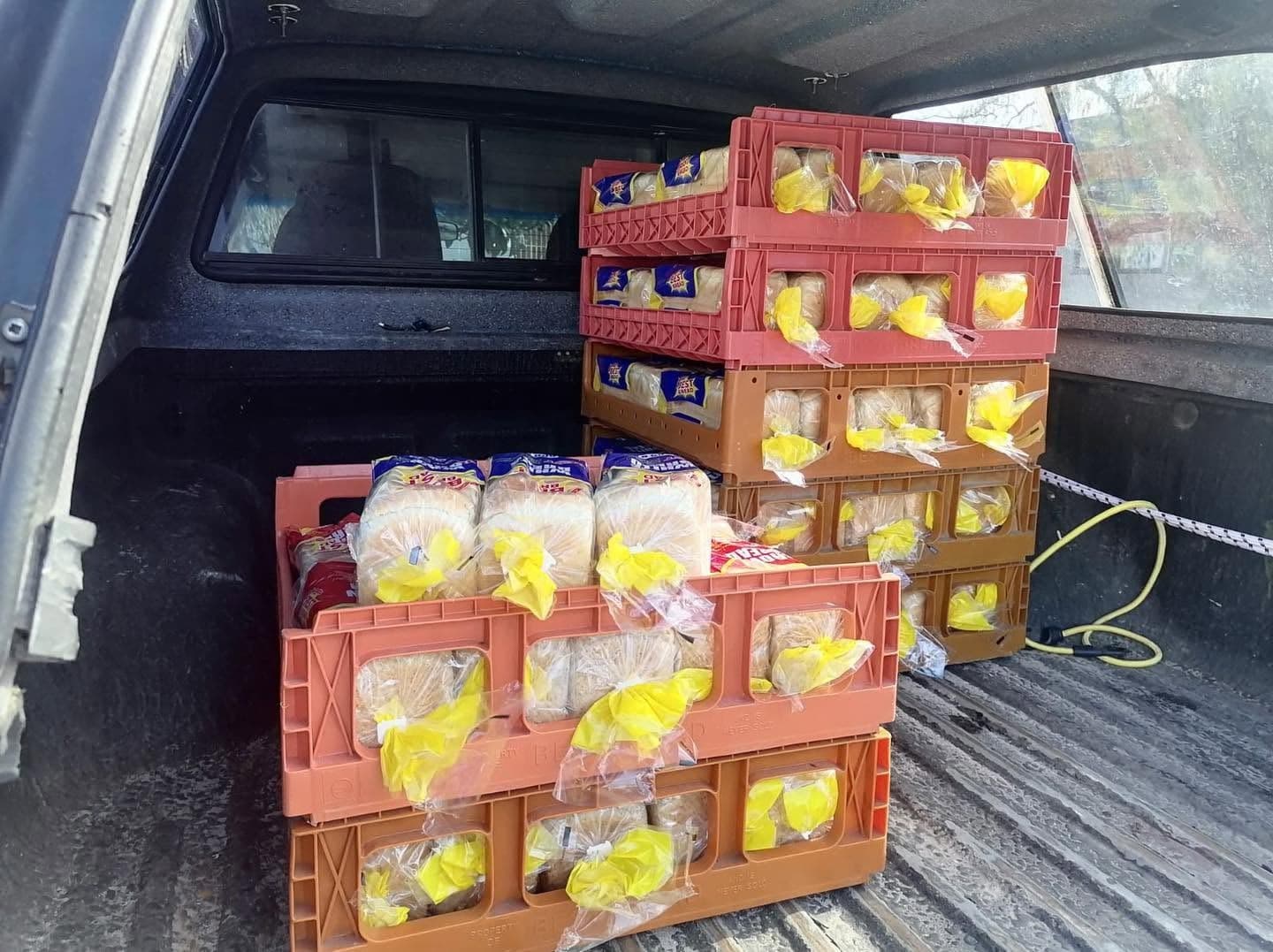 Loaves of bread packed into delivery crates in the back of a vehicle, ready for delivery